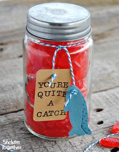 a jar filled with red liquid sitting on top of a wooden table next to scissors