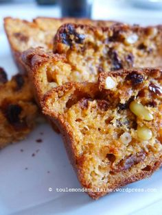 two pieces of bread on a plate with raisins and other food items in the background