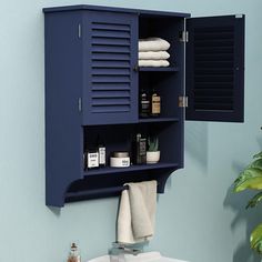 a bathroom with blue walls and white sink under a cabinet that has shutters on it