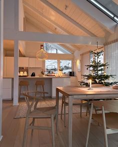 a dining room table with chairs and a small christmas tree in the middle of it