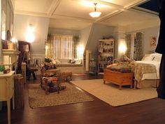 a living room filled with furniture next to a window covered in curtains and drapes