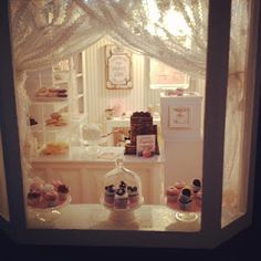 an open window with cupcakes and pastries in it