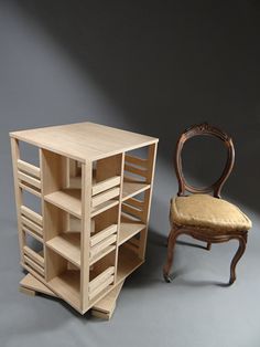 a chair next to a wooden shelf with shelves on each side, and a small stool in front of it