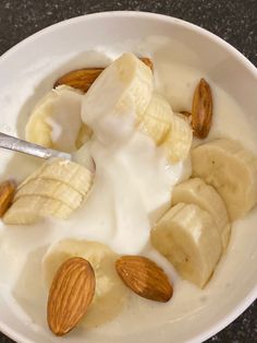 a bowl filled with yogurt, bananas and almonds