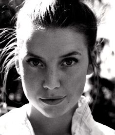 a black and white photo of a woman with her hair in a high pony tail