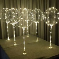 three lighted wine glasses sitting on top of a table