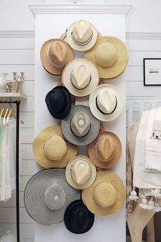 several hats are hanging on the wall in front of a white door with an instagramt