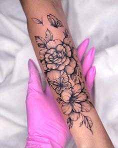 a woman's arm with flowers and butterflies on it