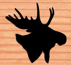 the silhouette of a moose's head on a wooden background