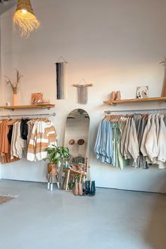 a room filled with lots of clothes hanging on the wall next to shelves and shoes