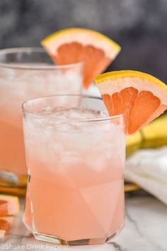 two glasses filled with pink lemonade and garnished with an orange slice