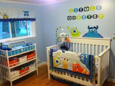 a baby's room decorated in blue and green with monsters on the wall, crib bedding and dresser