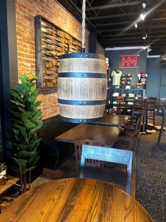 a wooden table with a light hanging from it's centerpiece in a restaurant