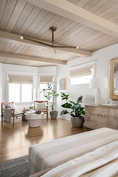 a living room filled with furniture and a large mirror on the wall next to a bed