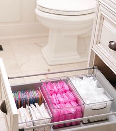 the drawers are filled with different types of toilet paper and other items for storage in this bathroom