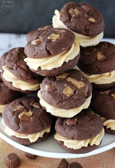 a white plate topped with chocolate cookies covered in frosting and peanut butter on top of each other