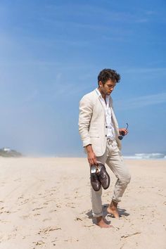 a man standing on the beach looking at his cell phone