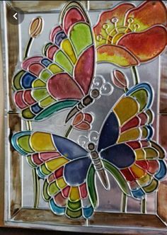 a colorful glass butterfly sitting on top of a wooden table