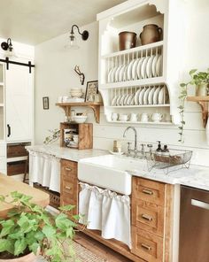 a kitchen with wooden cabinets and white dishes