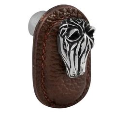 a zebra head is mounted on a brown leather door handle with an acrylic finish