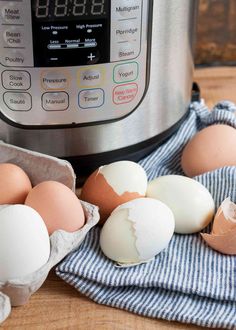 an instant pot with eggs in front of it on a blue and white dish towel