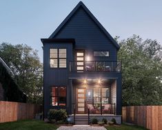 a house that is lit up at night with lights on the front and side windows