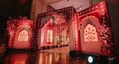 an elaborately decorated stage set up for a wedding ceremony with red and gold accents