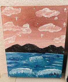 an acrylic painting of the ocean with mountains and clouds in the sky above it