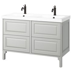 the double sink vanity has two black faucets on it's sides and is white