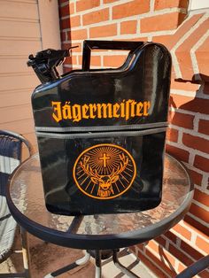 a black bag sitting on top of a metal table next to a brick wall and chair