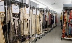 there are many dresses on display in the store, and one is for sale at the end of the aisle