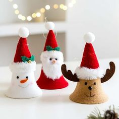 three christmas decorations with santa hats and reindeer antlers on the top one is made out of felt