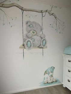 a baby's room with a teddy bear on a swing next to a tree branch