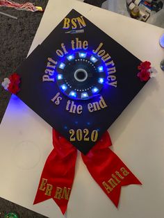 a graduation cap that has been decorated with blue and red lights on the front, which reads best of the journey is the end