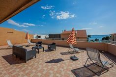 an outdoor patio area with chairs and umbrellas