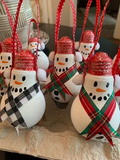 snowmen with hats and scarfs are sitting on a table