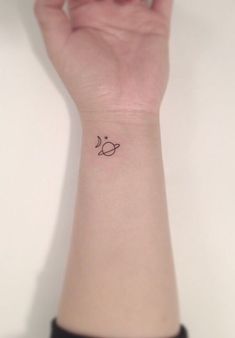 a person's wrist with a small tattoo on the left side of their arm