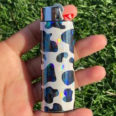 a person holding a lighter in their hand on some green grass and grass behind them