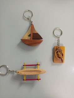 three wooden keychains are hanging on the wall with different shapes and materials in them