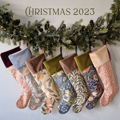 christmas stockings hanging on the wall in front of a sign that says christmas 2055