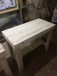 a table and two benches made out of plywood planks in a shop setting