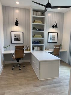 a home office with two desks and a ceiling fan