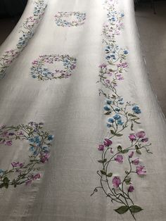 a white table cloth with blue and pink flowers on it