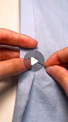 someone is cutting through the side of a piece of fabric with a pair of scissors