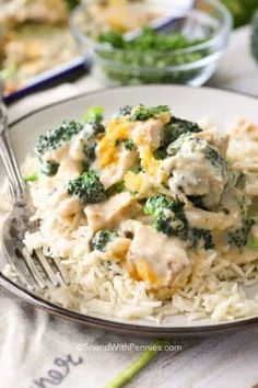 a white plate topped with chicken and broccoli covered in gravy on top of rice