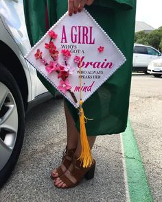 a girl is wearing a graduation cap and holding a tasseled sign that says, a girl who's got a brain