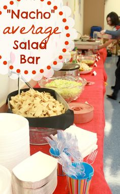 a long table with food on it and a sign that says nacho average salad bar