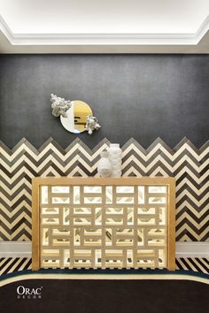 an art deco room with black and white chevrons on the wall, gold accents