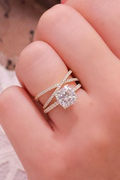 a woman's hand holding a diamond ring with two bands on the band and an open