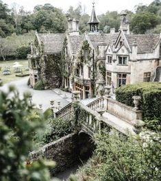 an old house with ivy growing on it's walls and roof, surrounded by greenery